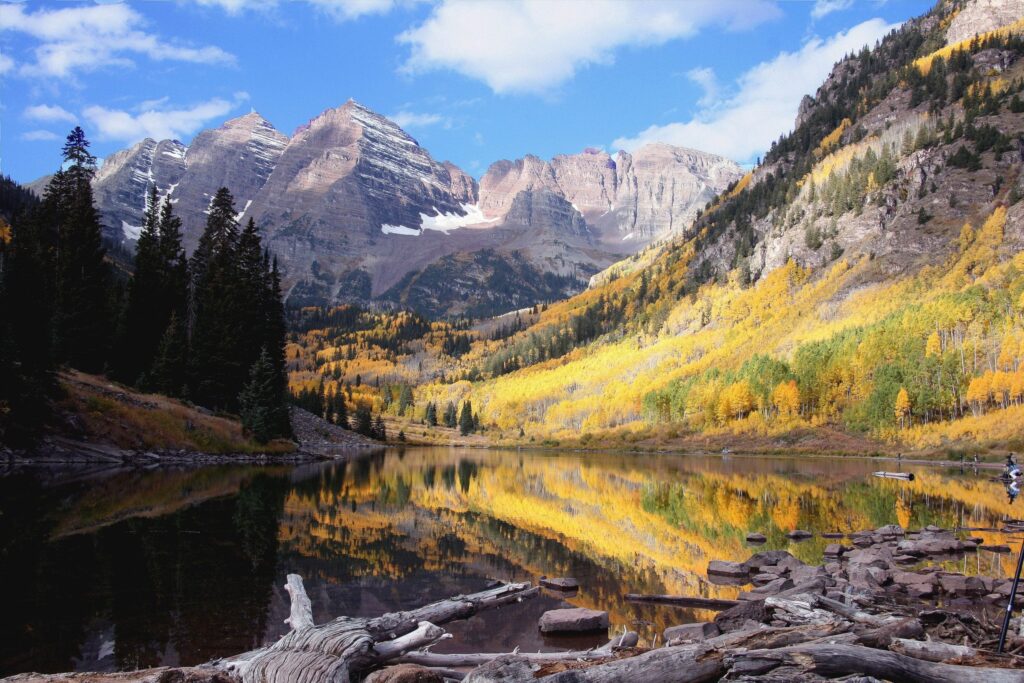 Fall foliage in Aspen reflected on serene alpine lake.